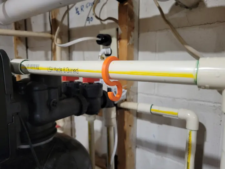 A 3D printed S hook custom sized to fit on a pipe.