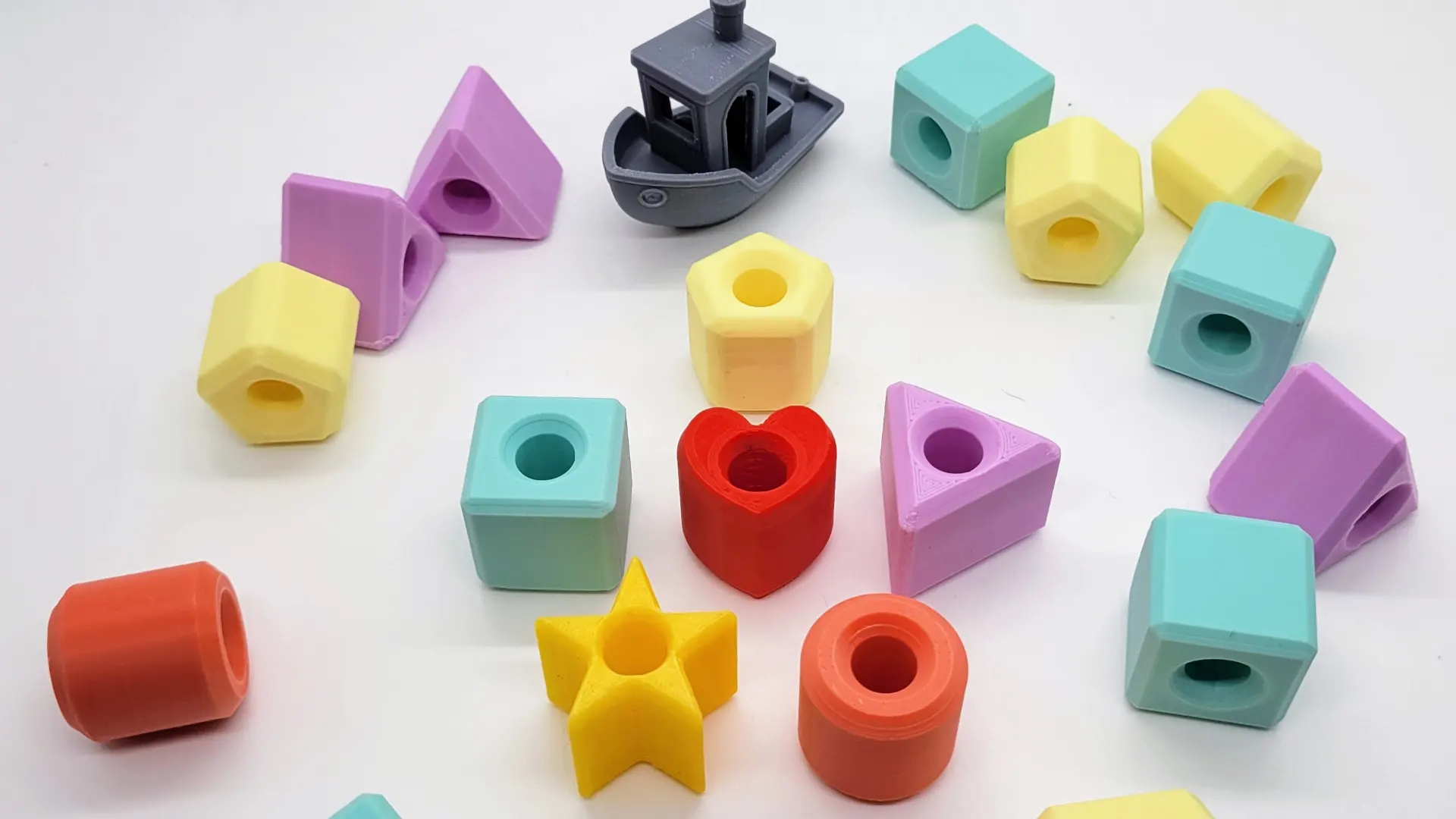 A render of several 3d printed geometrically shaped beads for teaching children to thread