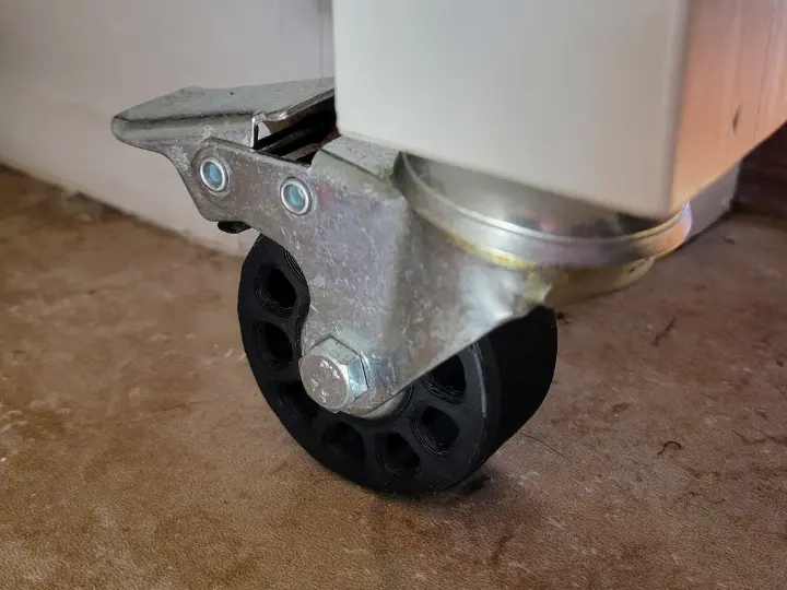 A 3D printed replacement caster wheel installed on a rolling cart.