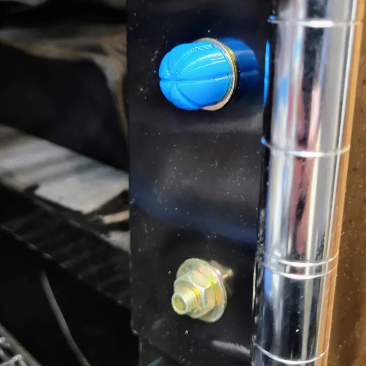A TPU 3D printed bolt cover placed overtop an exposed bolt.