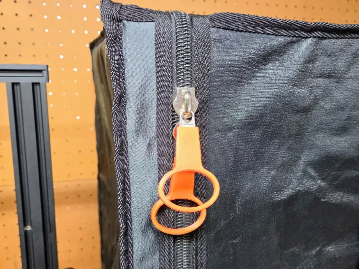 A 3D printed TPU zipper pull attached to a 3D printer resin tent.